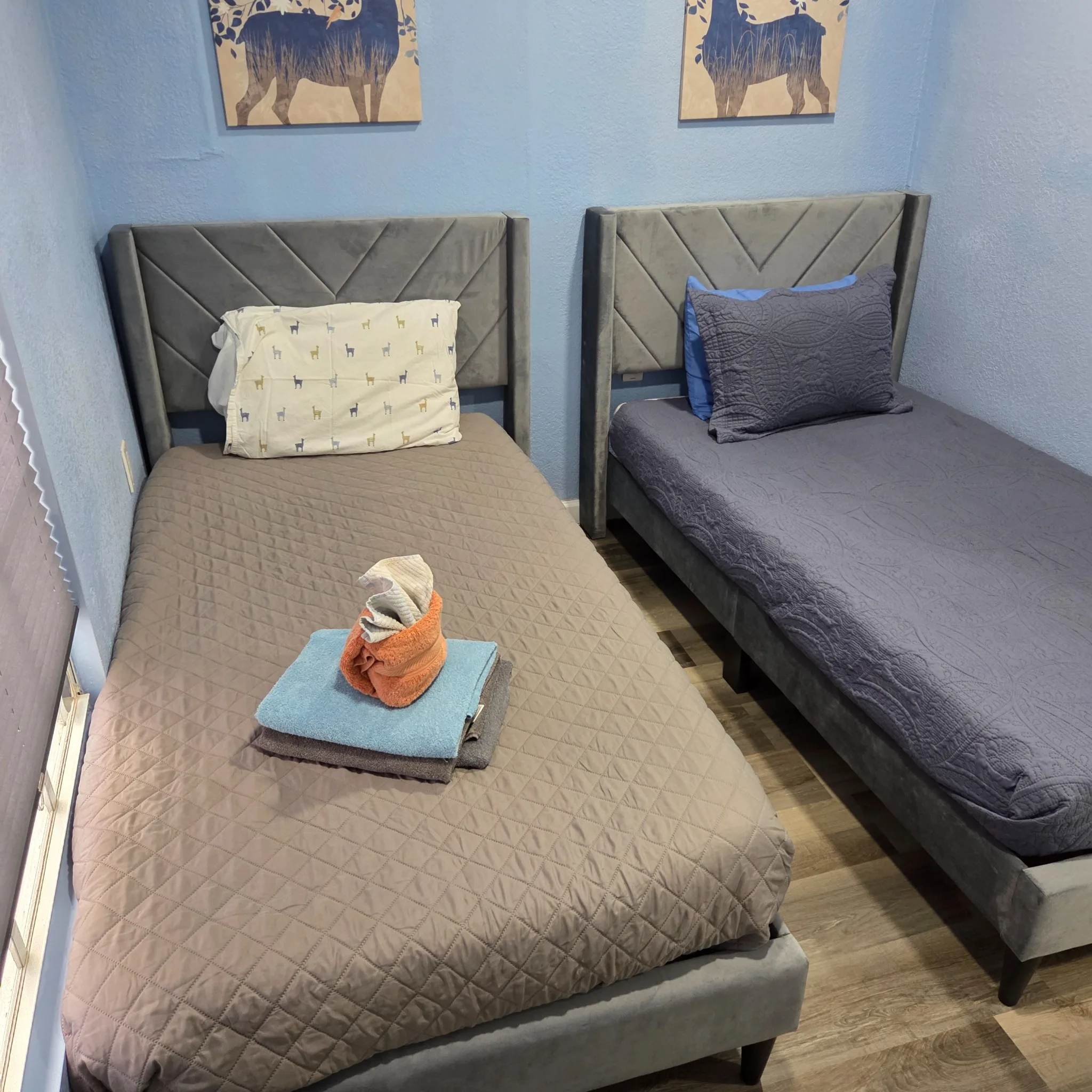 Original Small bedroom with two single beds, gray headboards, and simple decor.